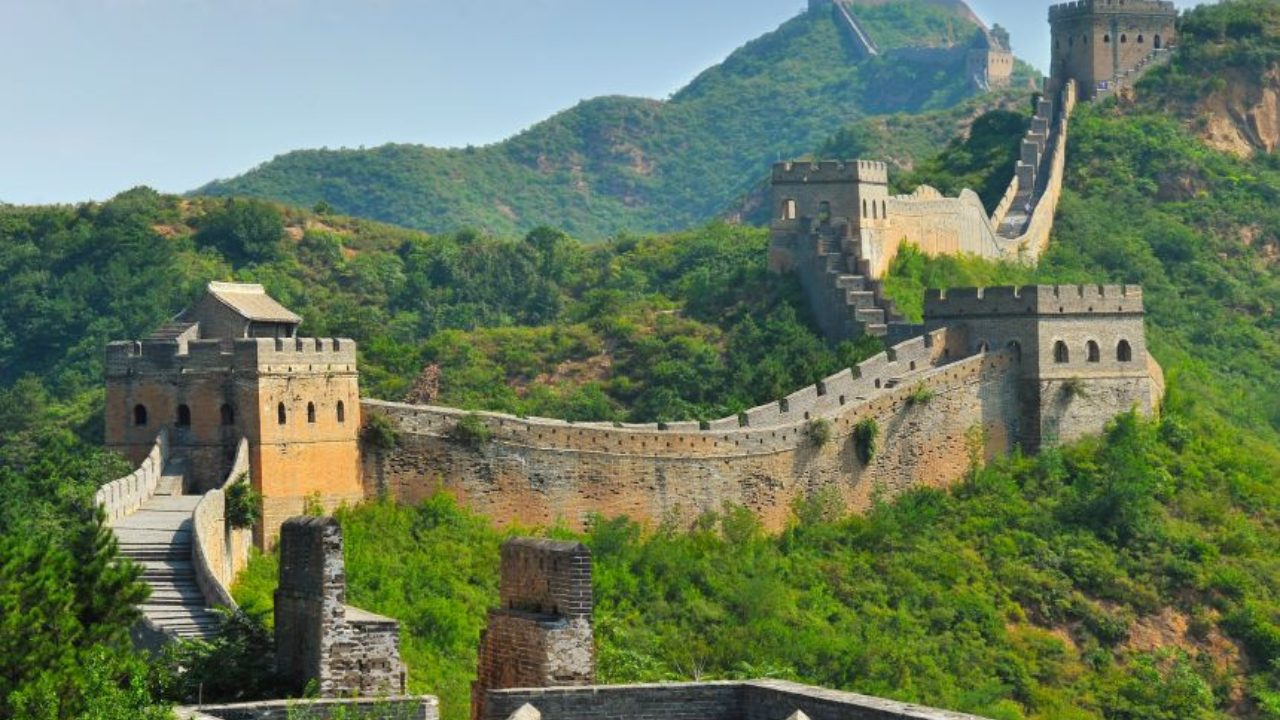 Great Wall of China began as fortifications built by various states during the Spring and Autumn and Warring States periods. Qin Shi Huang connected these walls to protect his dynasty from nomadic invasions. The walls were made of rammed earth and constructed using forced labor, stretching from Gansu to southern Manchuria by 212 BC.